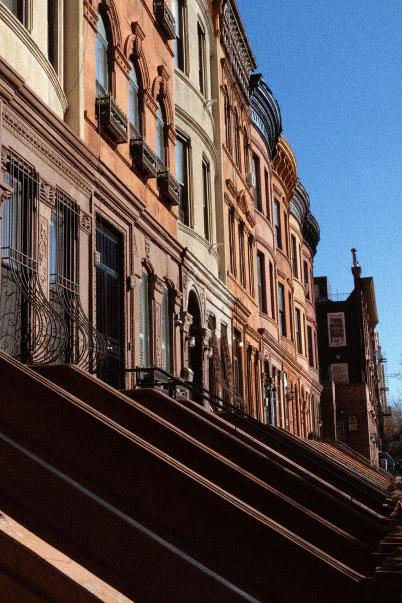 Colorful row of historic brownstone facades on a clear day.